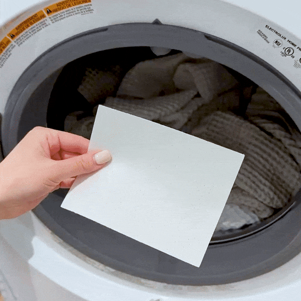 GIF of a person throwing a Laundry Leaf Detergent Sheet into a washing machine full of towels